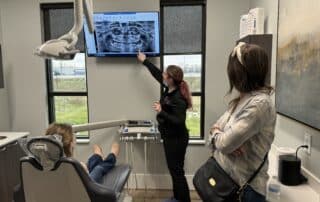 A photo of Dr. Lauren Wegrzyniak of Valley Advanced Orthodontics explaining something to a patient and her mom